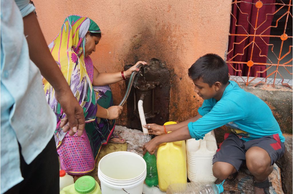 A woman and a child filling their water bottle_water rights