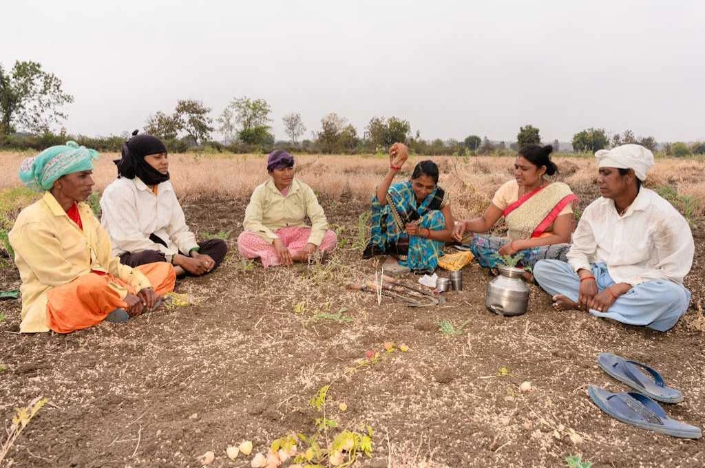 Farmers sitting in a group in a field_panchayat