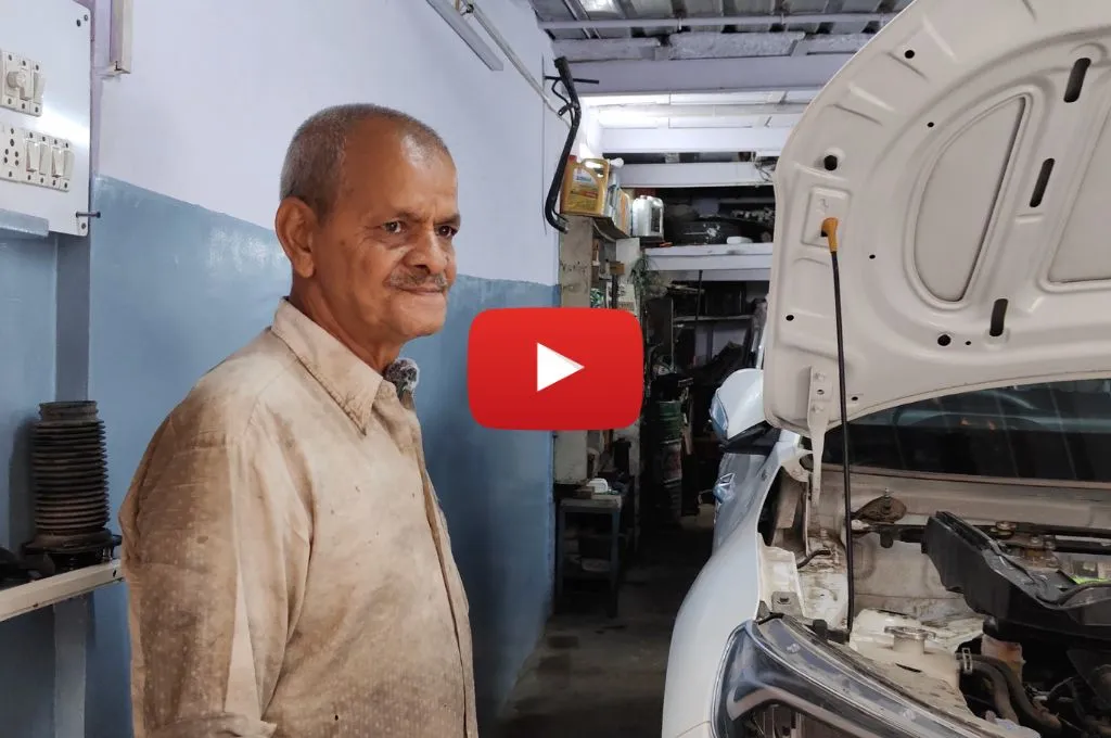 An auto mechanic standing beside a car-mechanics