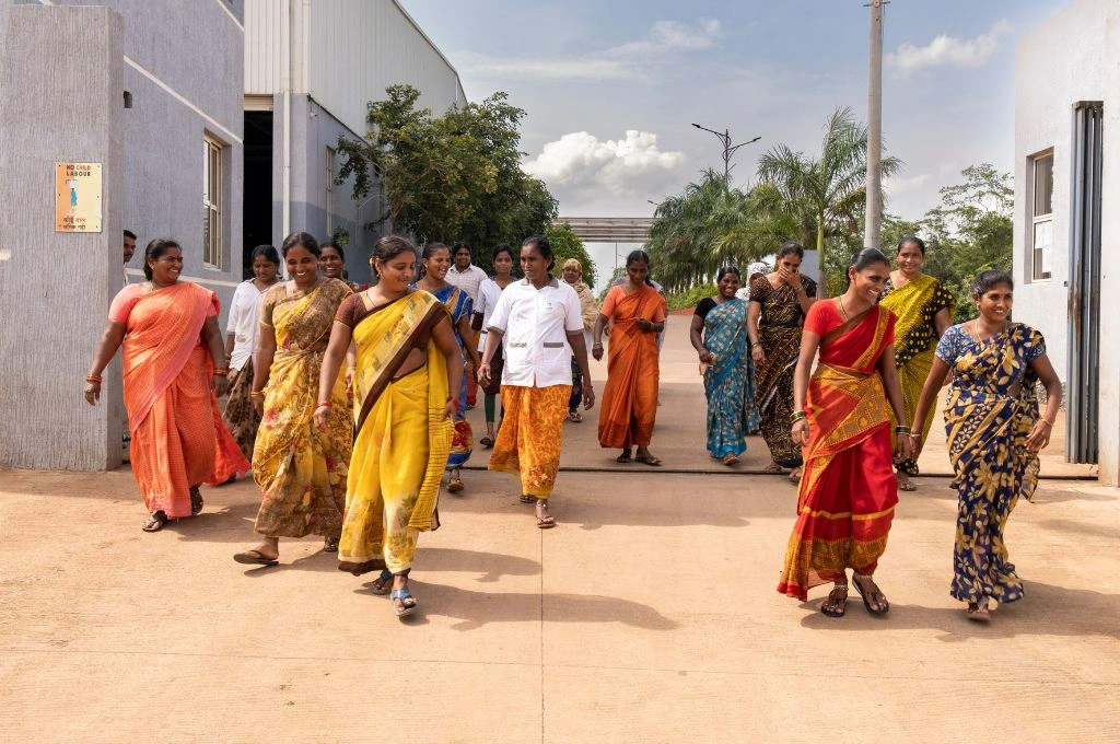 a group of women in saris walking out of an institute together-skill training