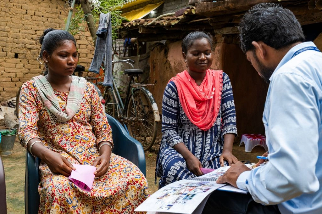 a man explaining something using a book to two young women-skill training