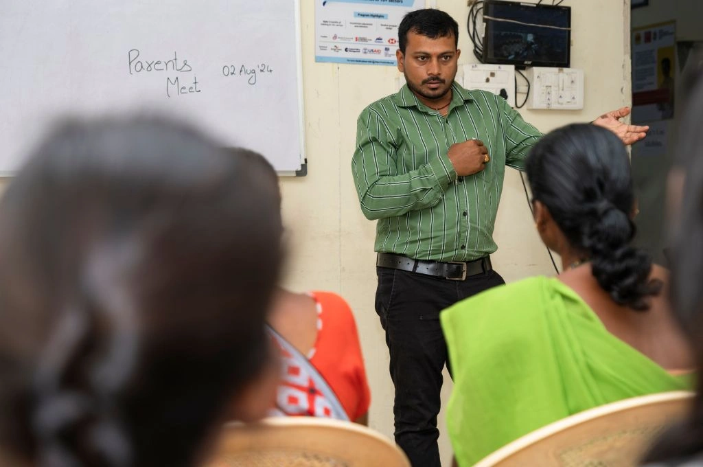a male trainer talking to parents at a skill training institute