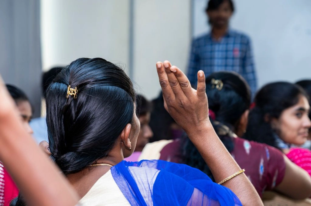 a girl with a raised hand in a classroom-skill training
