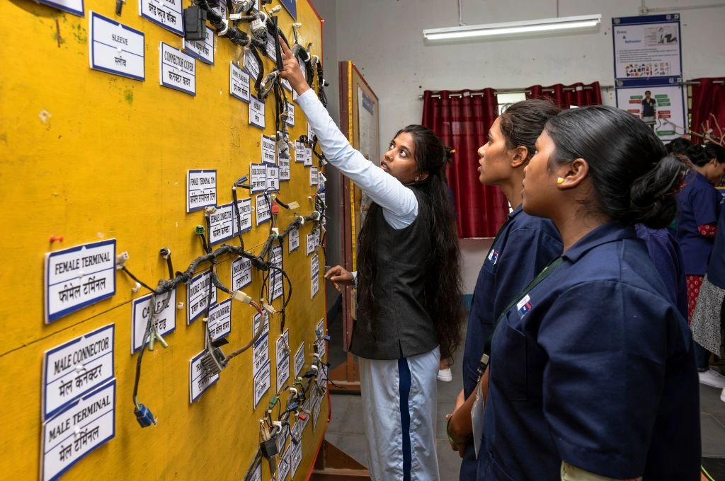 three young people making a plan on a notice board