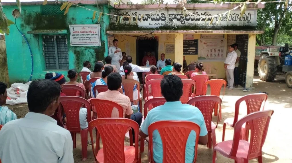 A group of people sitting on chairs in a meeting being conducted in an Indian village_data and policy