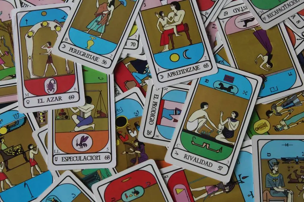 The image features a pile of colourful tarot cards, each with different figures drawn on it and with different names._Nonprofit humour