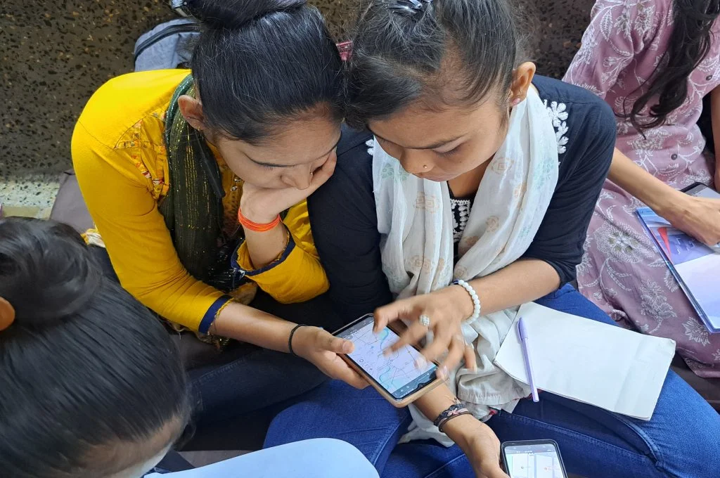 Two women using phone for mapping heat zones_urban heat