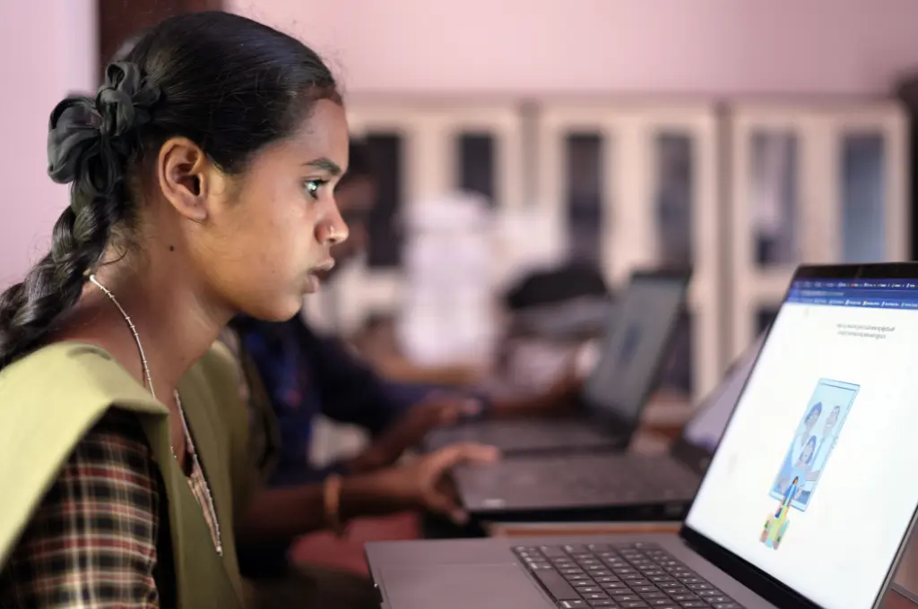 Girl in school uniform using laptop attentively_career guidance