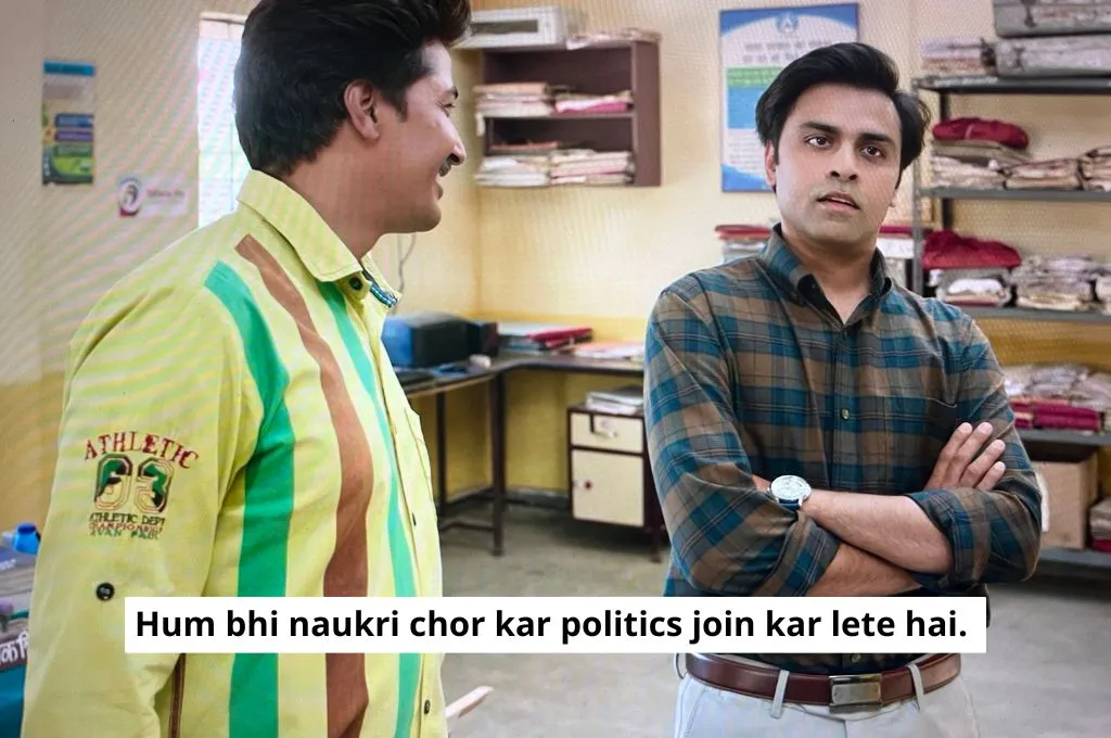 The image features the panchayat secretary and his assistant standing in the panchayat office. The assistant smiles and tells the secretary, "We should also quit our jobs and join politics"._Nonprofit humour