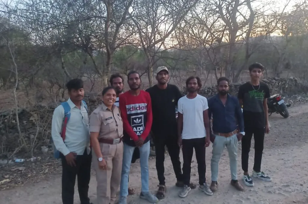 a female forest guard poses for a picture with local residents with a forest in the background--forest guard
