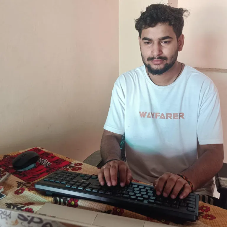 Gourav, a young man sitting a desk, typing--economic inclusion
