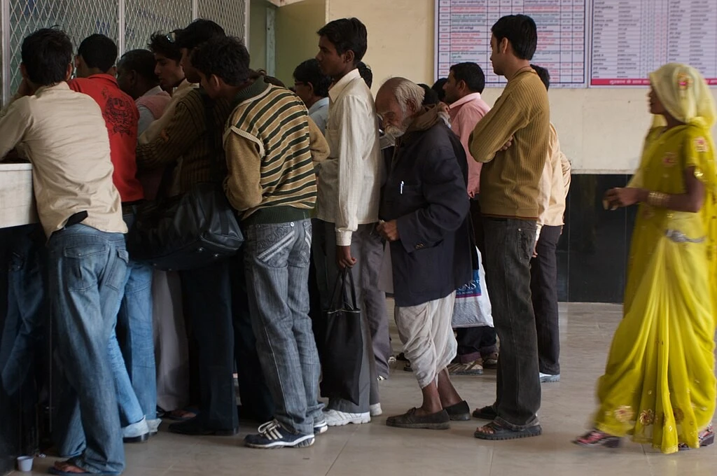 a group of people queued up in front of a window at a government office--Right to Information Act--