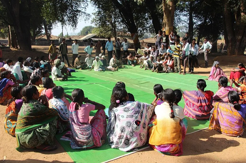 a large group of people sitting in a circle under 